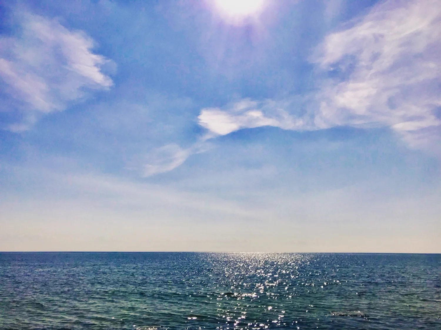 Photograph of the sea under a bright sky
